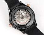 Black diver watch caseback with visible mechanical movement and rose-gold crown accents.