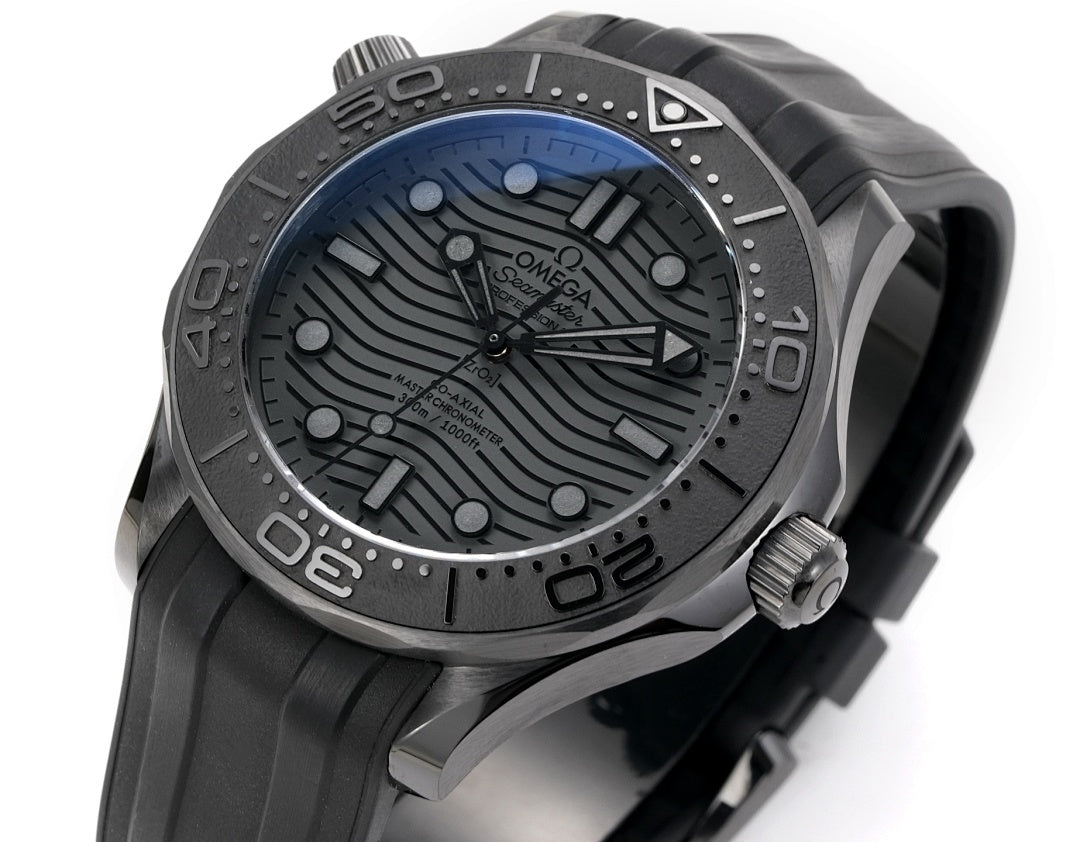 Omega Seamaster watch dial close-up with black textured pattern and luminous markers.