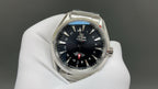 Steel wristwatch with dark dial, gold accents, and integrated bracelet links