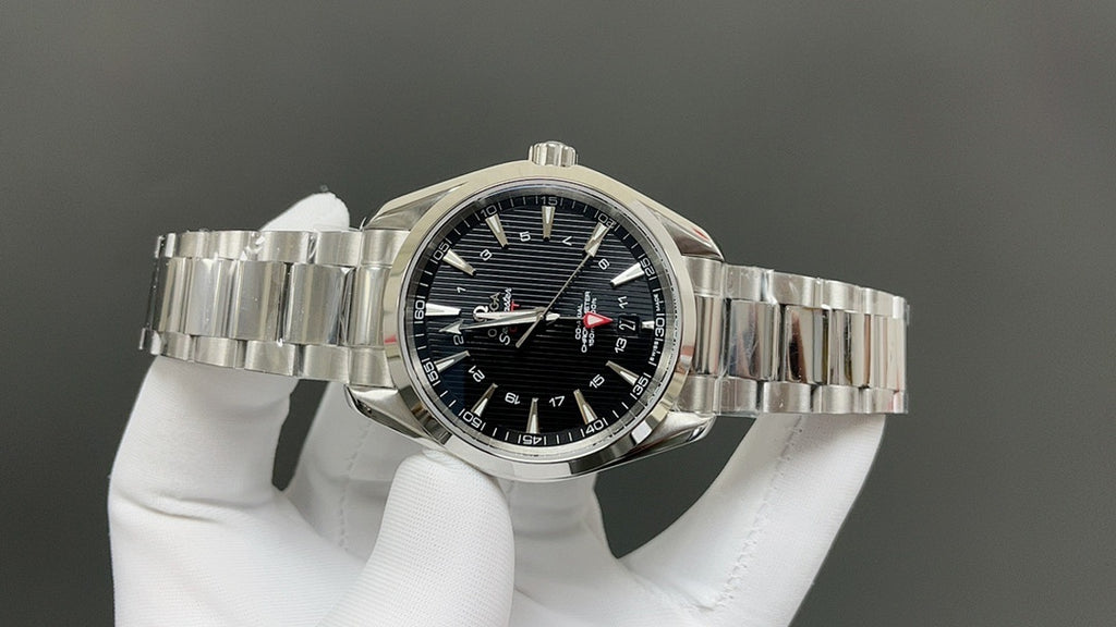Steel bracelet wristwatch with dark dial, luminous markers, and gold-tipped accents