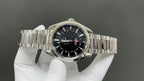 Steel bracelet wristwatch with dark dial, luminous markers, and gold-tipped accents