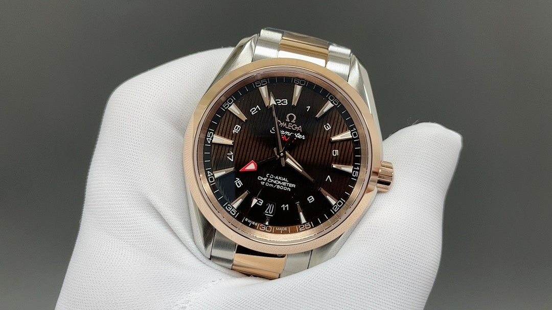 Two-tone rose-gold and steel wristwatch with dark dial, held on white glove