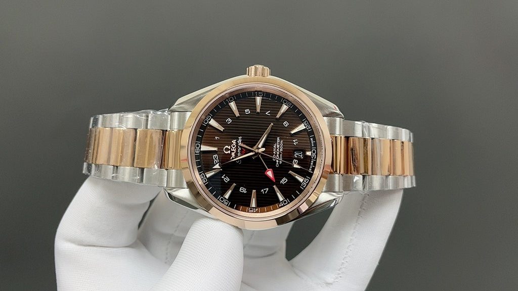 Rose-gold bezel two-tone wristwatch with dark dial and three hands on bracelet
