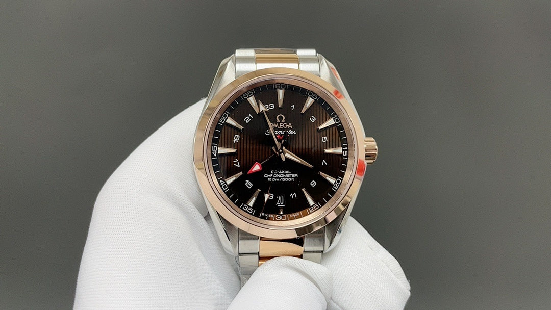 Rose-gold and steel wristwatch with dark dial, gold bezel, and three hands