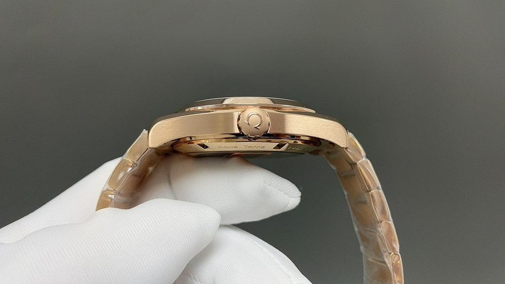 Gold wristwatch case top and crown detail, metal link band visible