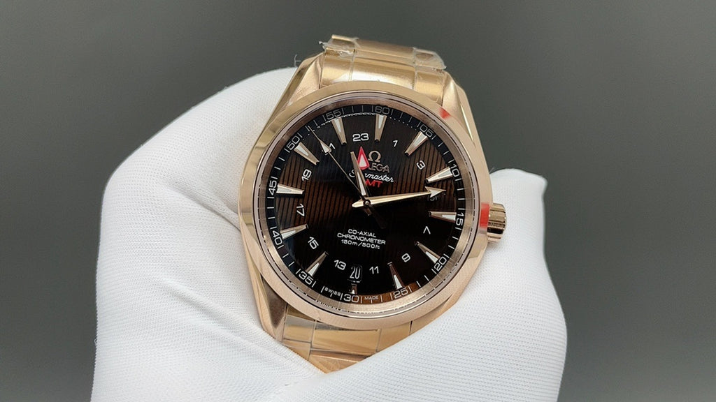 Gold Omega wristwatch with black dial, red seconds hand and date window