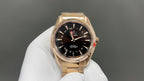Gold Omega wristwatch with black dial, multiple subdials and metal link band