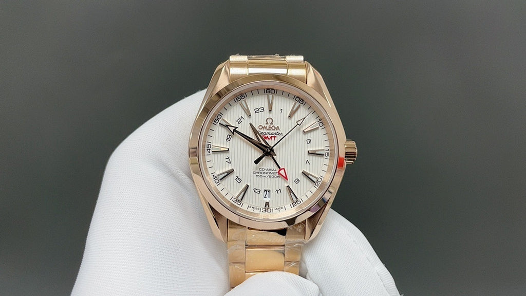 Omega watch with gold case and white dial, metal bracelet on display