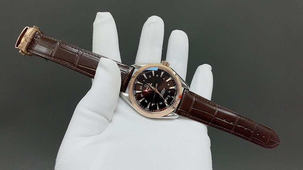 Analog wristwatch with gold-tone case, black dial, and brown leather strap