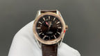 Analog wristwatch with black dial and gold-tone case, brown leather strap
