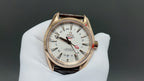 Analog wristwatch with gold-tone case, white dial, and brown leather strap
