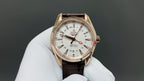 Analog wristwatch with gold-tone case, white dial, and brown leather strap