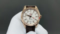 Omega watch with gold-tone case, white dial, and brown leather strap