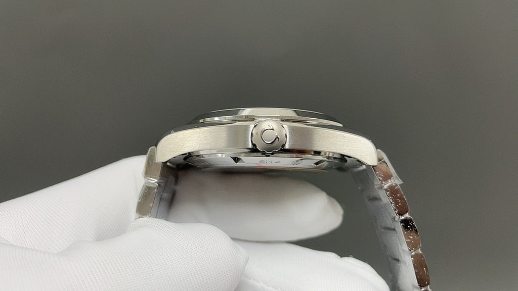 Omega watch caseback close-up with raised C emblem and polished silver metal