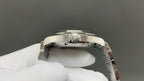 Omega watch caseback close-up with raised C emblem and polished silver metal