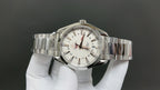 Omega watch with silver bracelet, white dial, red-accent hands, and date window