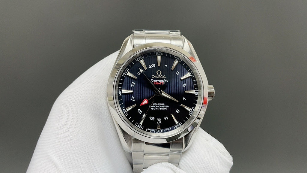 Omega watch with deep blue dial, red accents, and silver metal bracelet