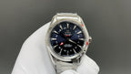Omega watch with deep blue dial, red accents, and silver metal bracelet