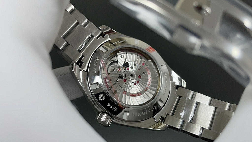 Omega watch with silver metal bracelet and transparent caseback showing movement