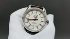 Omega watch with white dial, silver case, and brown leather strap