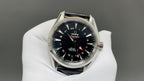Omega watch with black dial and blue hour markers, silver bezel, black leather strap