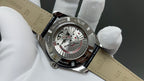 Omega watch open caseback with visible movement and tan leather strap