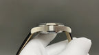 Omega watch side profile with silver case and black leather strap