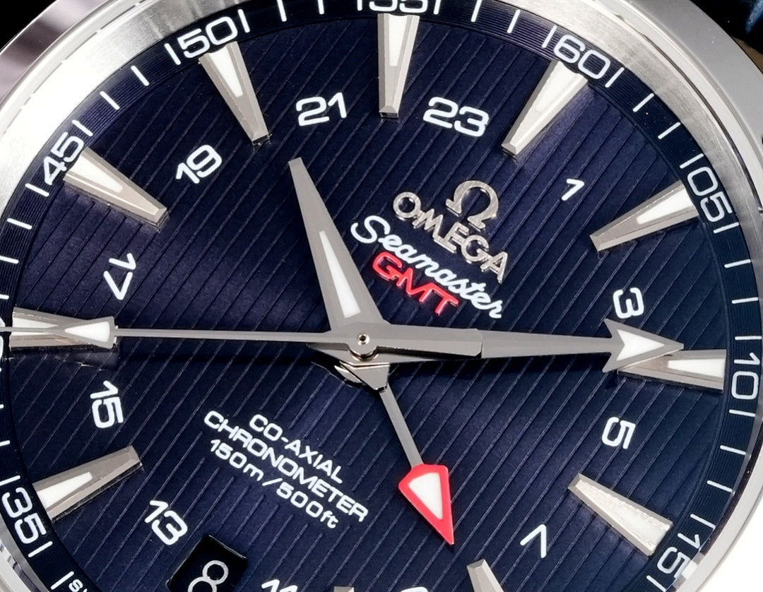 Omega wristwatch dial closeup with navy textured surface and silver hour markers.