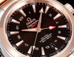 Omega Seamaster GMT watch dial close-up with dark face and rose-gold markers
