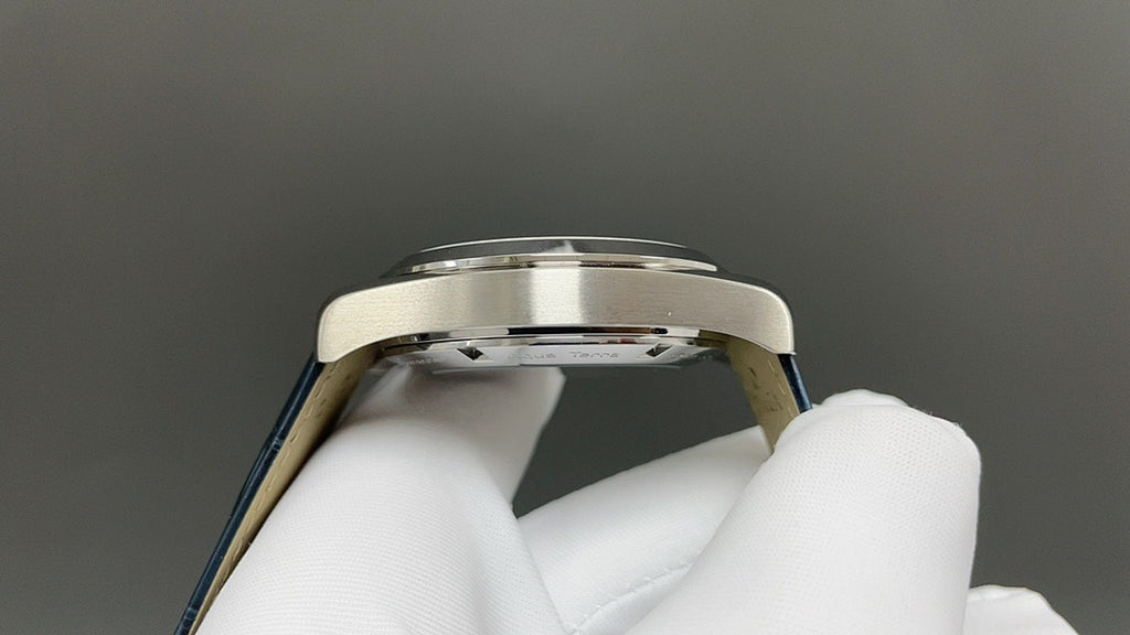 Wristwatch case side view with polished bezel and blue strap edge