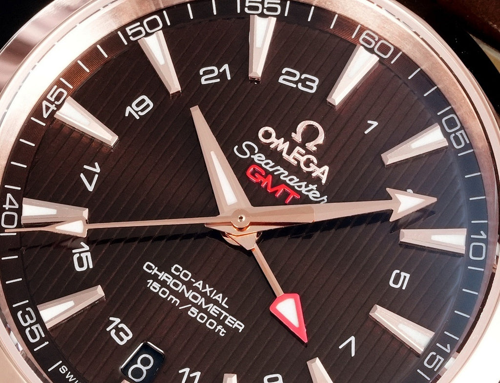 Close-up of dark dial wristwatch with rose-gold hands and Omega Seamaster GMT text