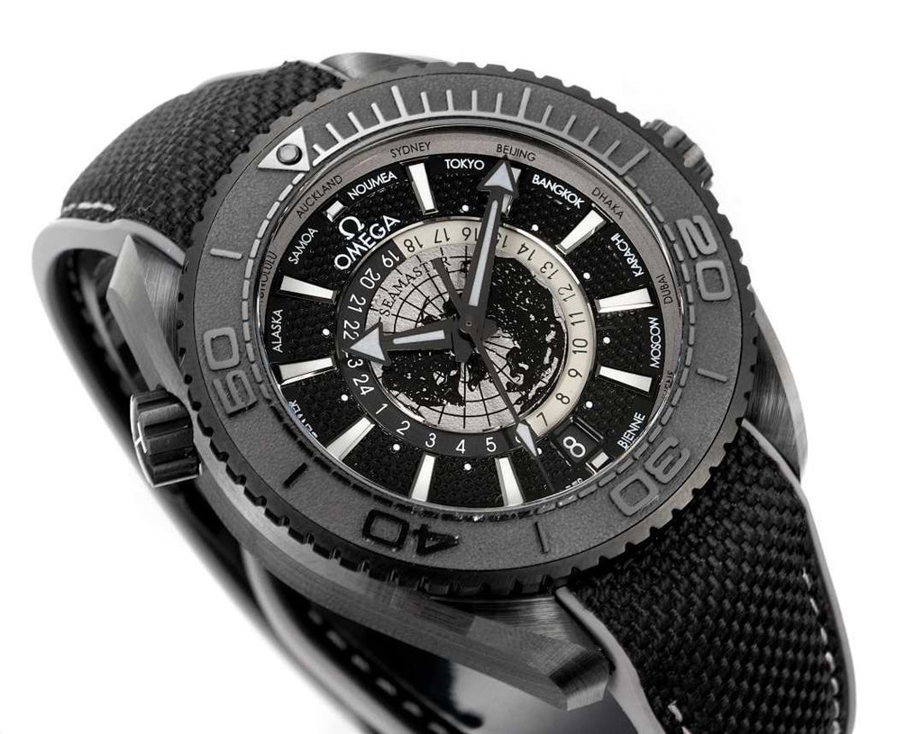 Omega watch dial close-up with world-time ring and black fabric strap
