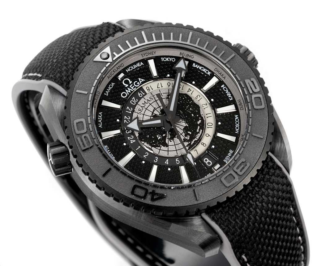 Omega watch dial close-up with world-time ring and black fabric strap