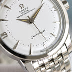 Close-up of Omega Seamaster watch dial with gold-accent hands and silver bezel