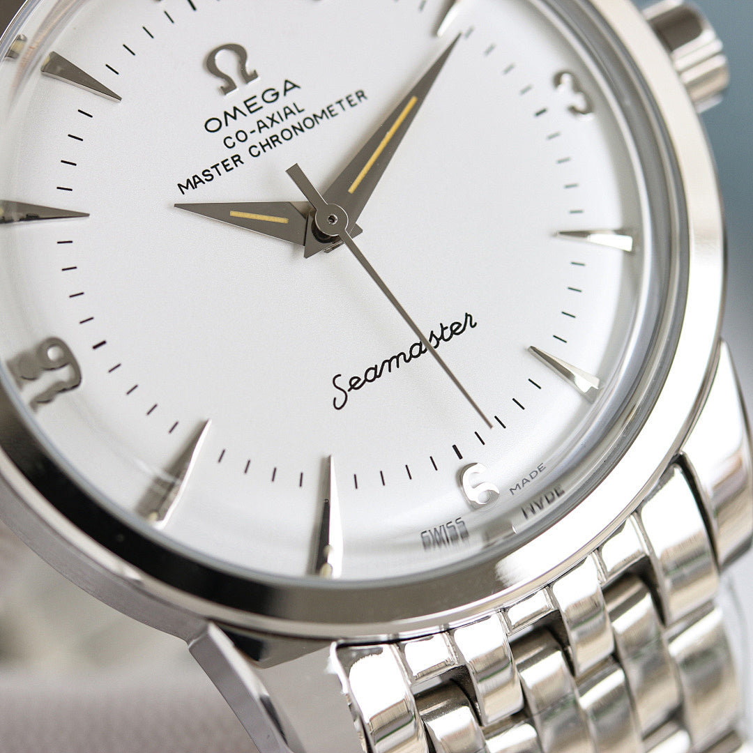 Close-up of Omega Seamaster watch dial with gold-accent hands and silver bezel