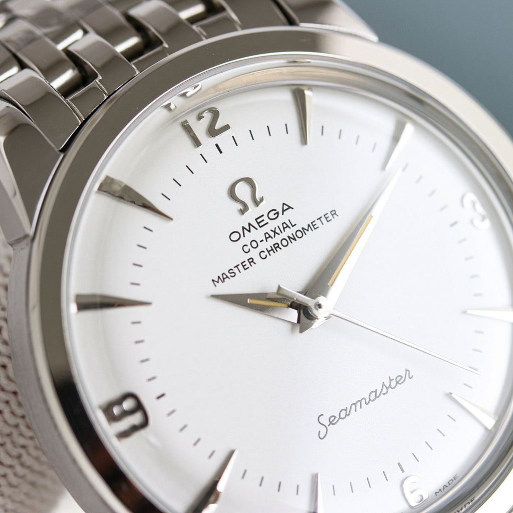 Close-up of Omega Seamaster watch face with gold hands and silver metal bezel