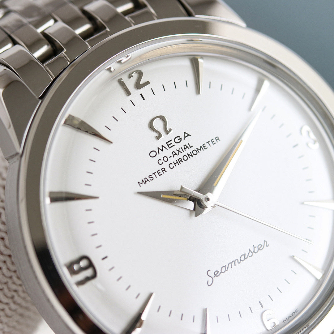 Close-up of Omega Seamaster watch face with gold hands and silver metal bezel