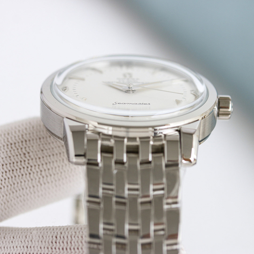 Omega Seamaster watch with silver metal bracelet, round case, and white dial