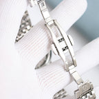 Stainless steel watch bracelet links with folding clasp and strap adjustment detail