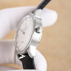 Silver analog wristwatch with black leather strap, crown and diamond bezel side view