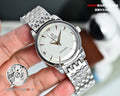 Silver metal wristwatch with white dial and gold hour/minute hands, link bracelet