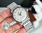 Silver metal wristwatch with white dial and gold hour/minute hands, link bracelet
