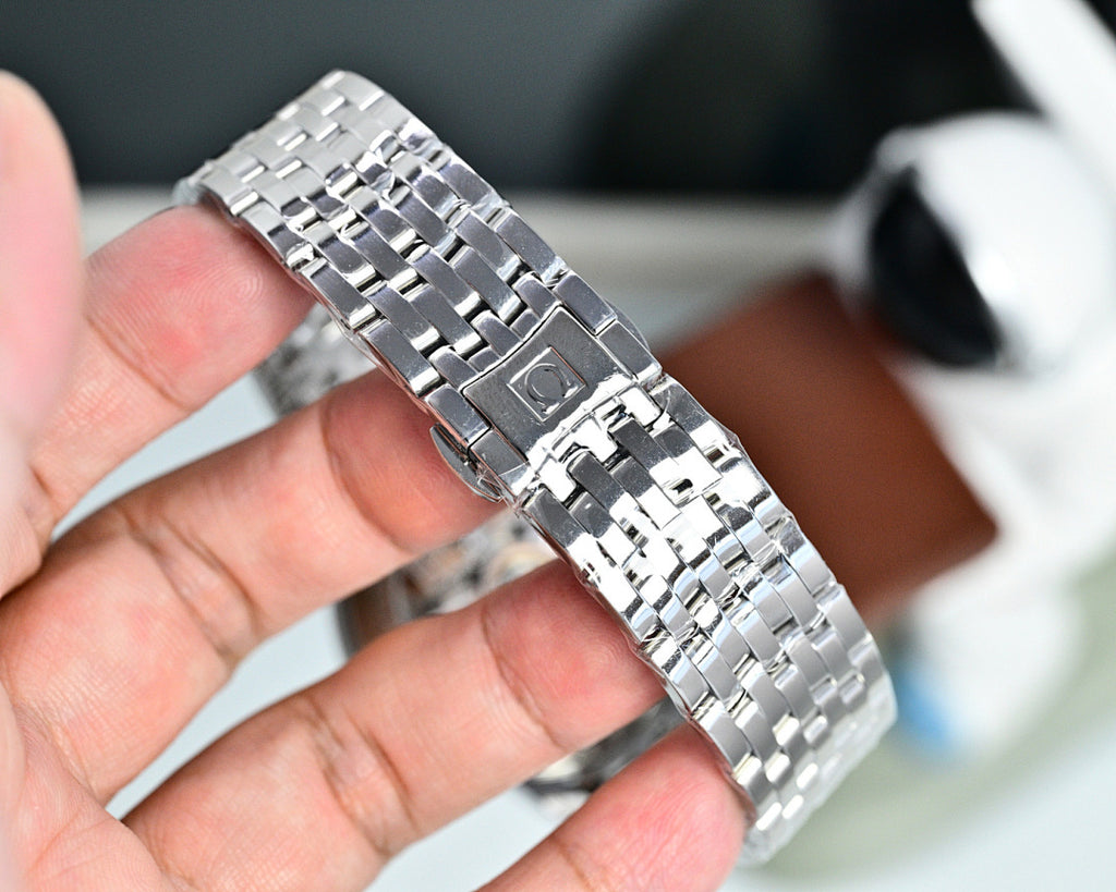 Silver metal wristwatch bracelet and case, polished links held in a hand