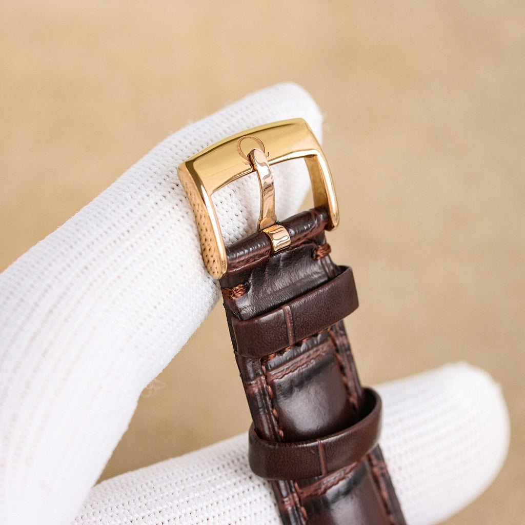 Brown leather watch strap with rose-gold buckle and case side detail