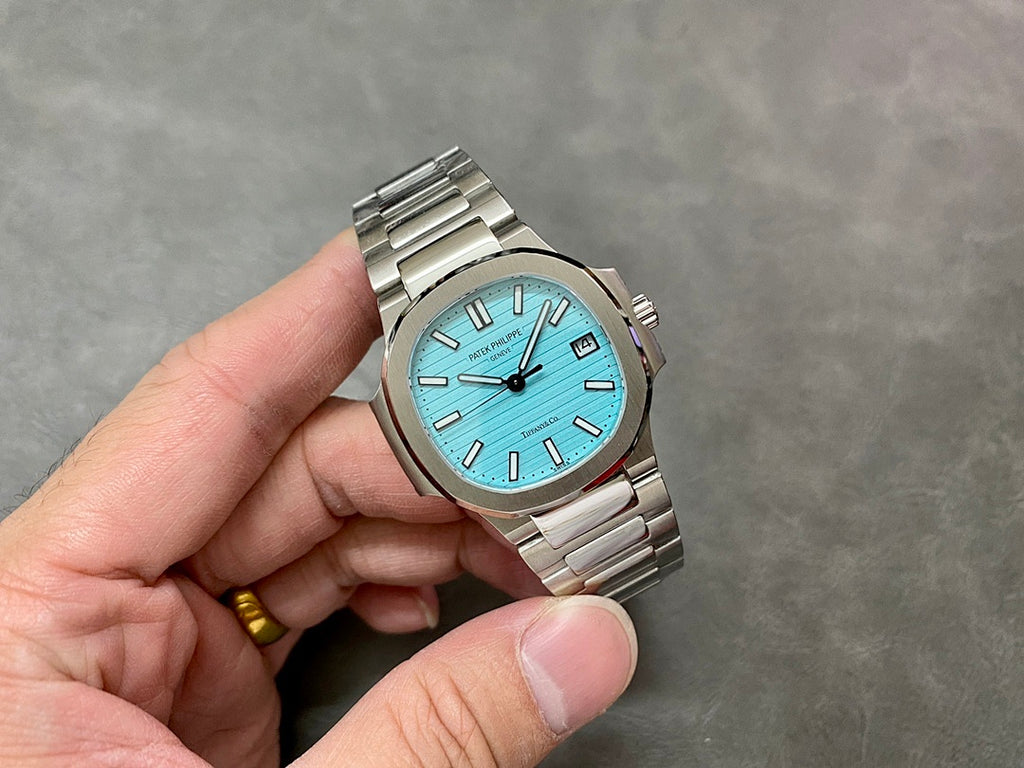 Patek Philippe wristwatch with light blue dial and silver-tone bracelet, angled view