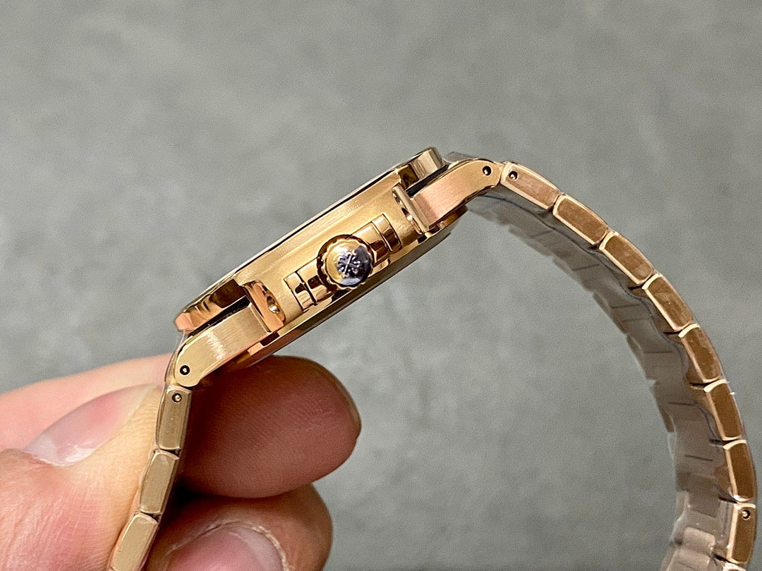 Patek Philippe watch clasp and caseback, gold-tone bracelet held upright