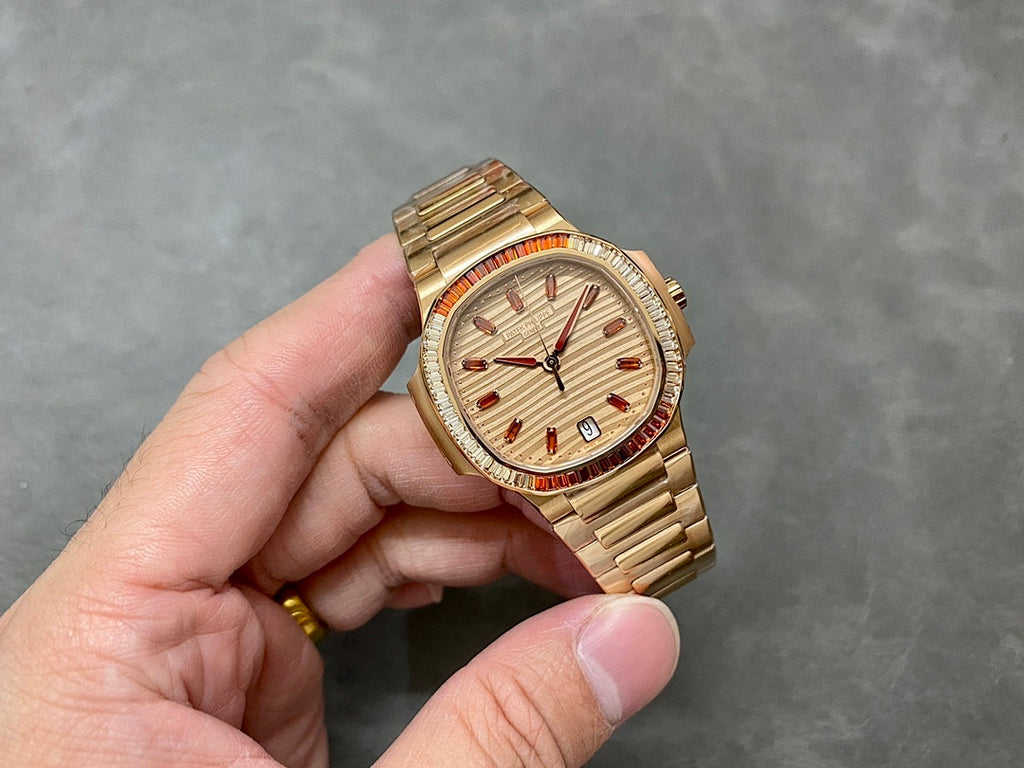 Patek Philippe wristwatch with gold-tone bracelet, cream dial and red bezel accents
