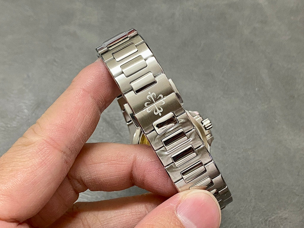 Wristwatch bracelet clasp with engraved emblem and polished link pattern