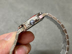 Wristwatch side view with crown and polished metal case, metal bracelet link