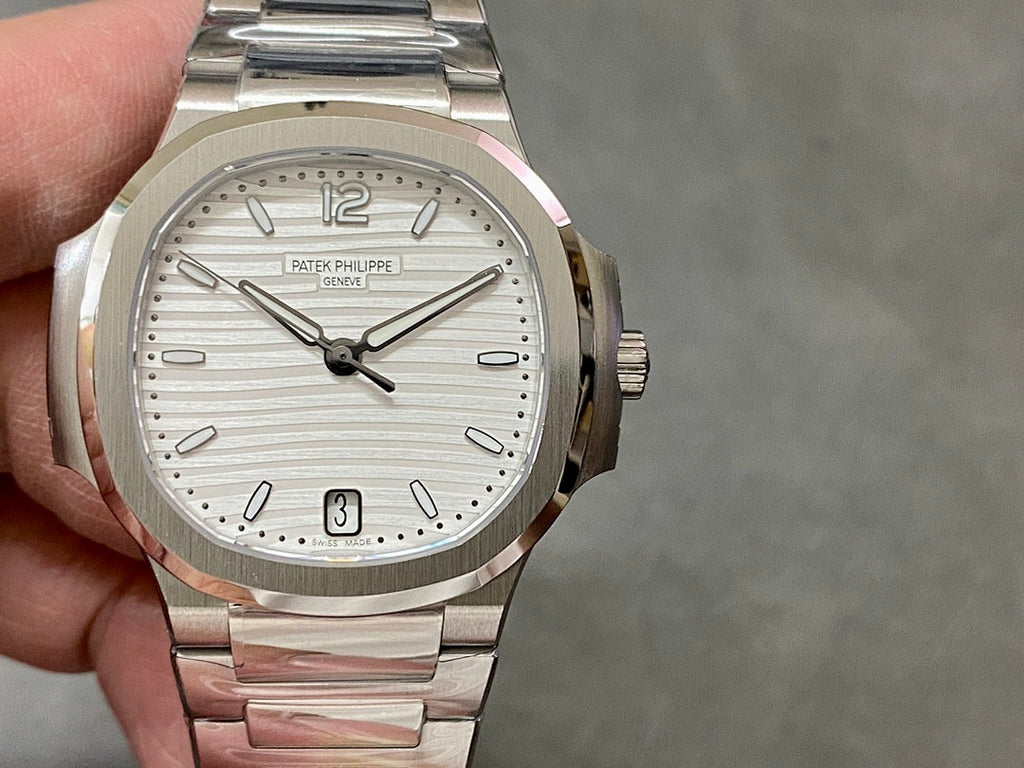 Wristwatch front view with silver dial, baton markers, date window at 3, steel bracelet
